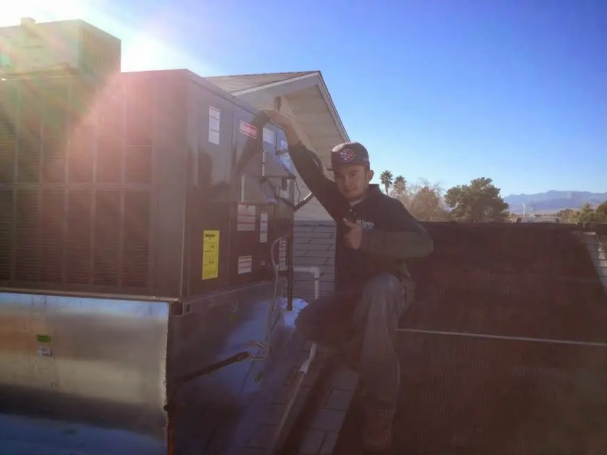 HVAC technician performing Boiler Repair on a rooftop unit in Zebulon